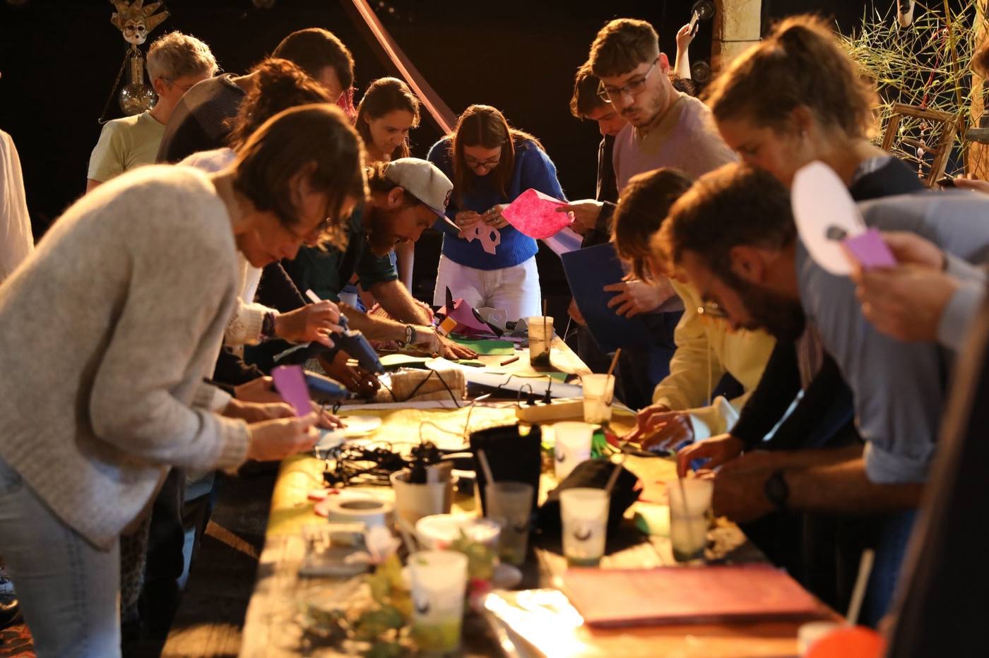 Un atelier créatif autour d'une grande table, à la lueur des bougies